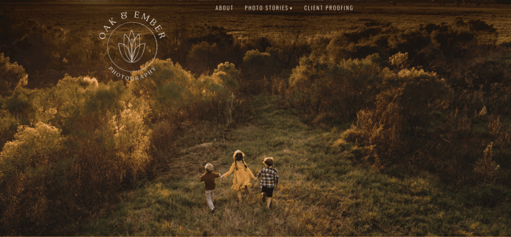 A website image of Oak & Ember Photography where three kids are playing in an open field